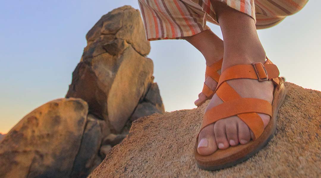 Person on a rock, sporting Chaco Women's Wayfarer sandals.
